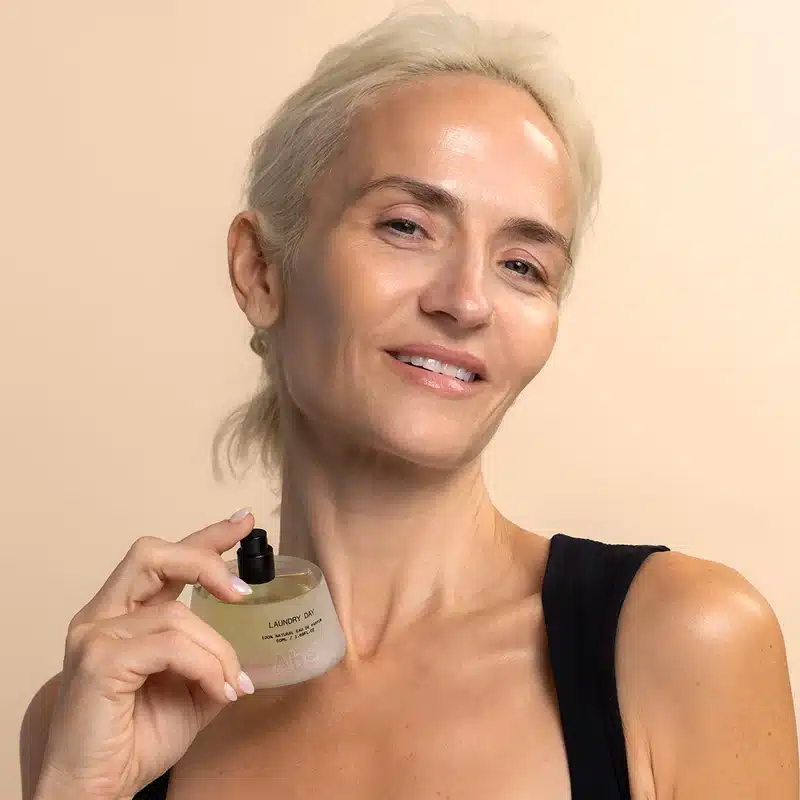 A woman spritzing Abel Fragrance laundry Day