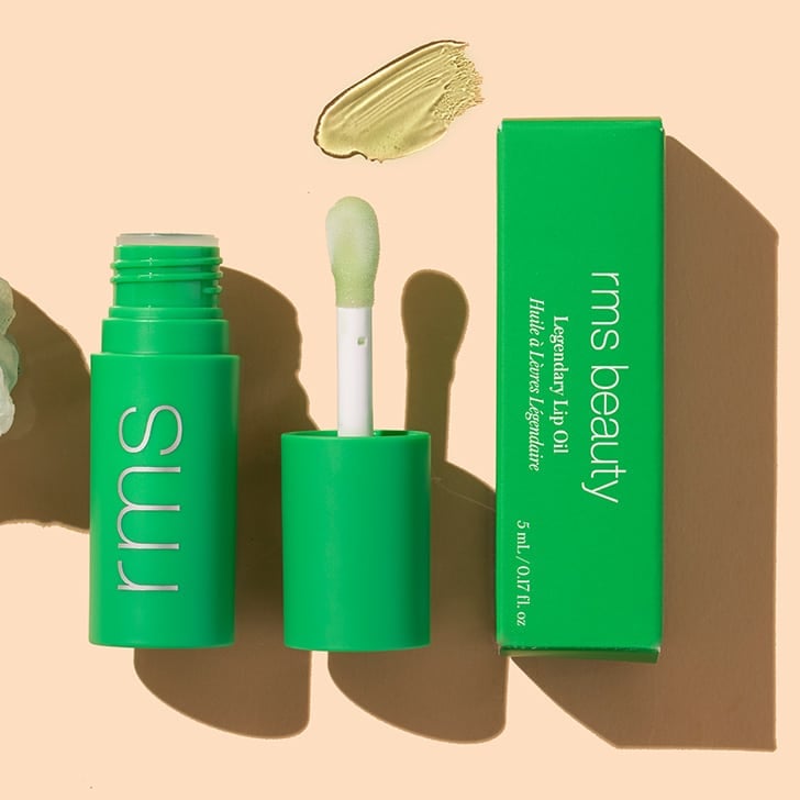 RMS Beauty Legendary Lip Oil in shade chameleon, green lip product with box on peach background with product swatch