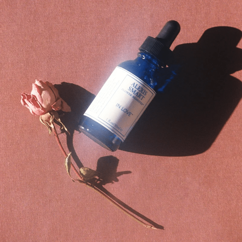 Alexis Smart's In Love bottle lying next to a tulip