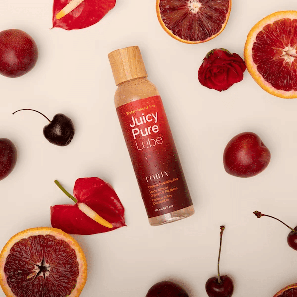 Foria Juicy Pure Lube surrounded by grapefruit and cherries